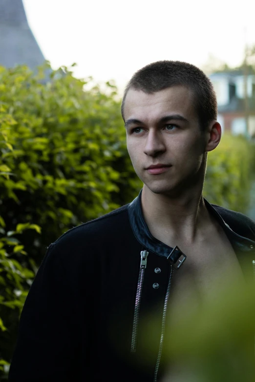 a man standing in front of some bushes, unsplash, photorealism, portrait of beautiful young man, portrait sophie mudd, brown buzzcut, cinematic shot ar 9:16 -n 6 -g