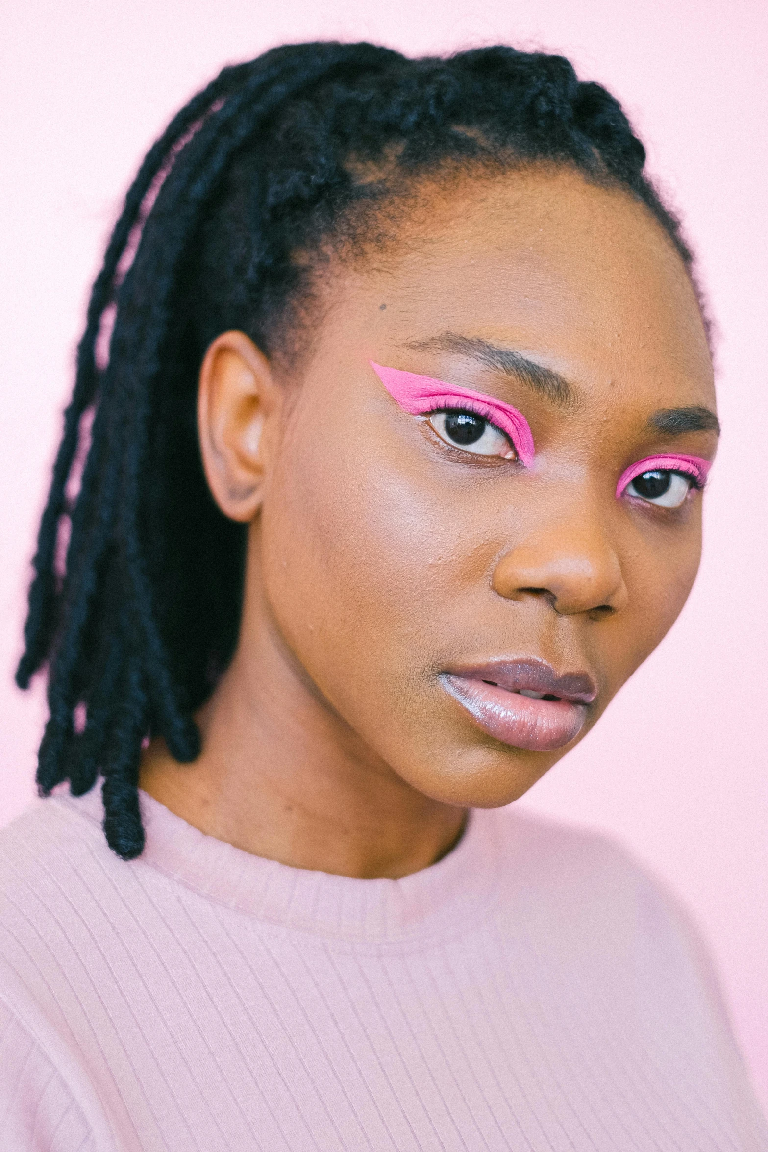 a woman with pink eyeliners and a pink sweater, inspired by Carl Walter Liner, trending on pexels, afrofuturism, winged eyeliner, looks a blend of grimes, full product shot, halfbody headshot