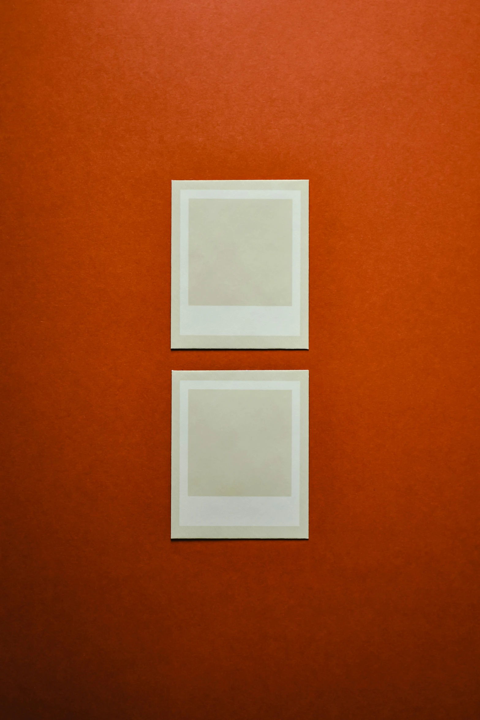 a couple of white frames sitting on top of a red wall, unsplash, medium format, ocher, icon, moma