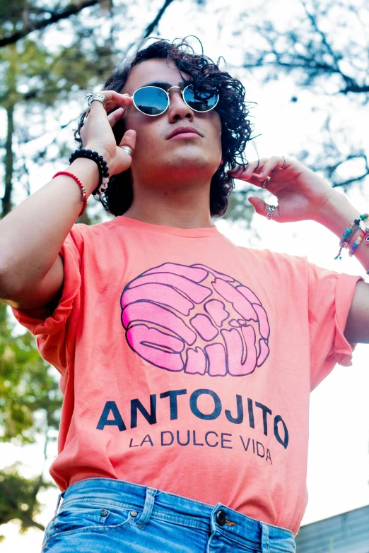 a woman holding a cell phone up to her ear, inspired by Antonín Chittussi, featured on instagram, antipodeans, wearing an orange t-shirt, donatello, latino features, outlive streetwear collection