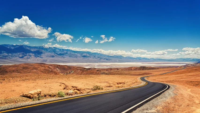 an empty road in the desert with mountains in the background, by Julia Pishtar, trending on unsplash, death valley, chocolate river, panoramic photography, on a bright day