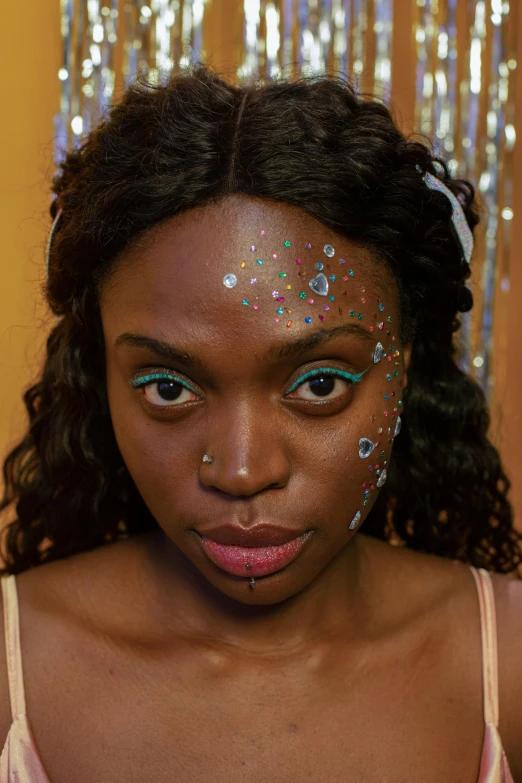 a close up of a woman with glitter on her face, an album cover, by artist, afrofuturism, gemstone forehead, teal eyebrows, starry eyes, close - up studio photo