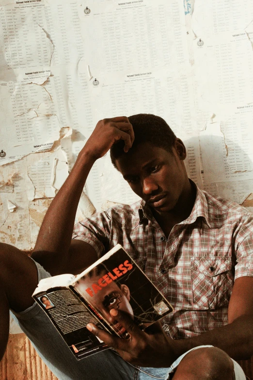 a man sitting on a couch reading a book, an album cover, pexels contest winner, ghanaian movie poster, a photo of a disheveled man, student, ignant