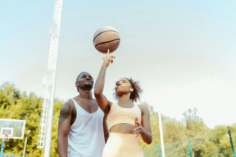 a man and a woman playing a game of basketball, by Matija Jama, pexels contest winner, happening, sydney park, skies behind, wearing a camisole and shorts, a tall