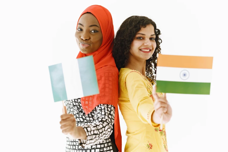 a couple of women standing next to each other holding flags, by Matija Jama, shutterstock, renaissance, indian girl with brown skin, muslim, irish, 🚿🗝📝