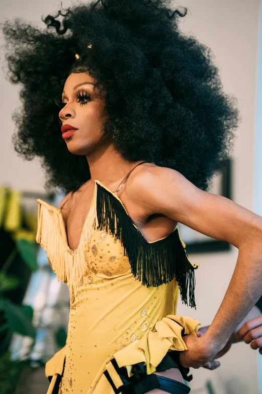 a man standing next to a woman in a yellow dress, by Winona Nelson, trending on pexels, renaissance, ru paul\'s drag race, long afro hair, performance, portrait of black mermaid