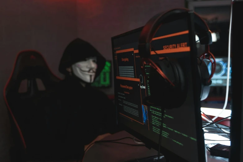 a person in a hoodie sitting in front of a computer, cyberpunk art, pexels, halloween, wearing a black robe, wearing bandit mask, avatar image