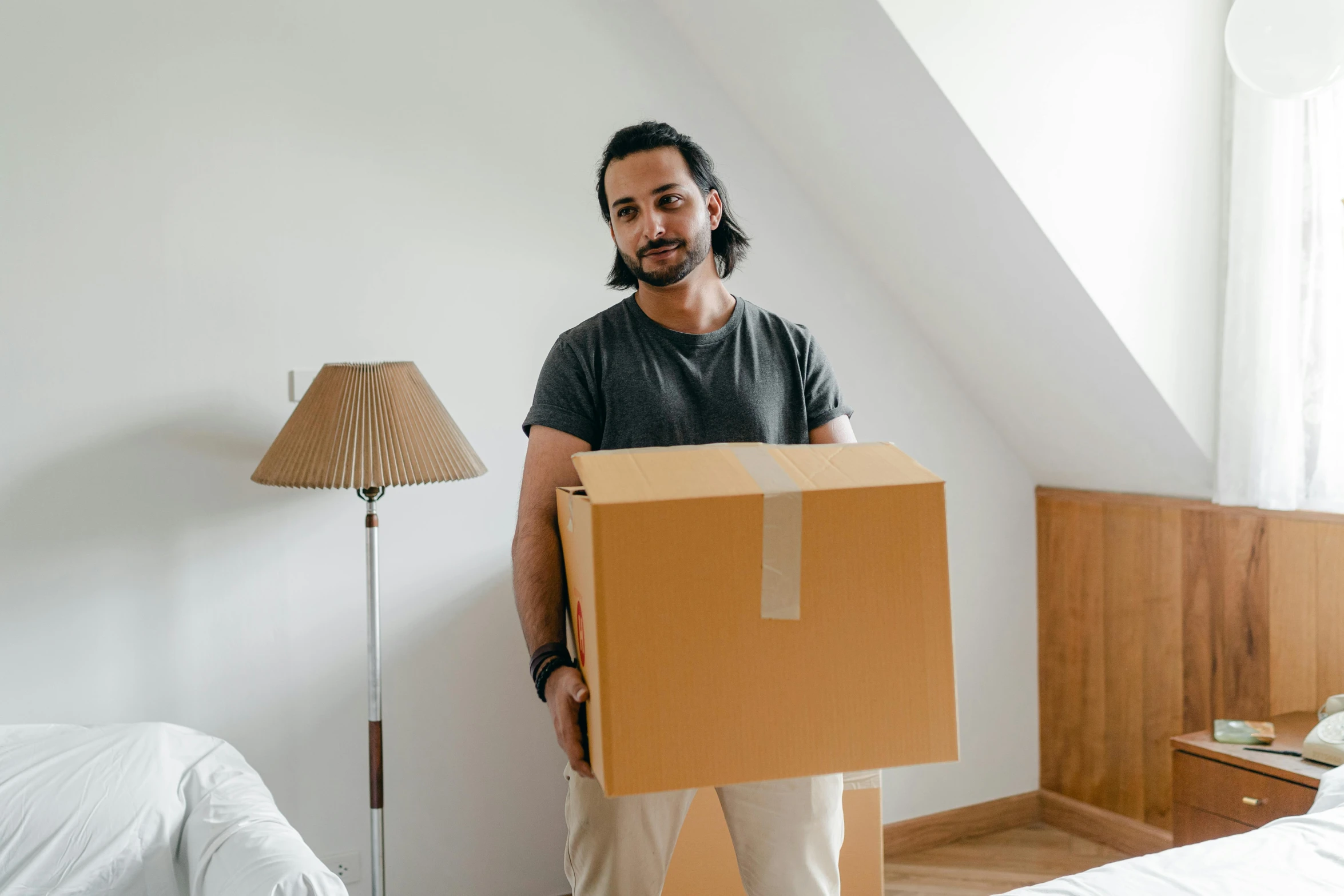 a man standing in a bedroom holding a box, pexels contest winner, hurufiyya, avatar image, melbourne, delivering parsel box, ad image