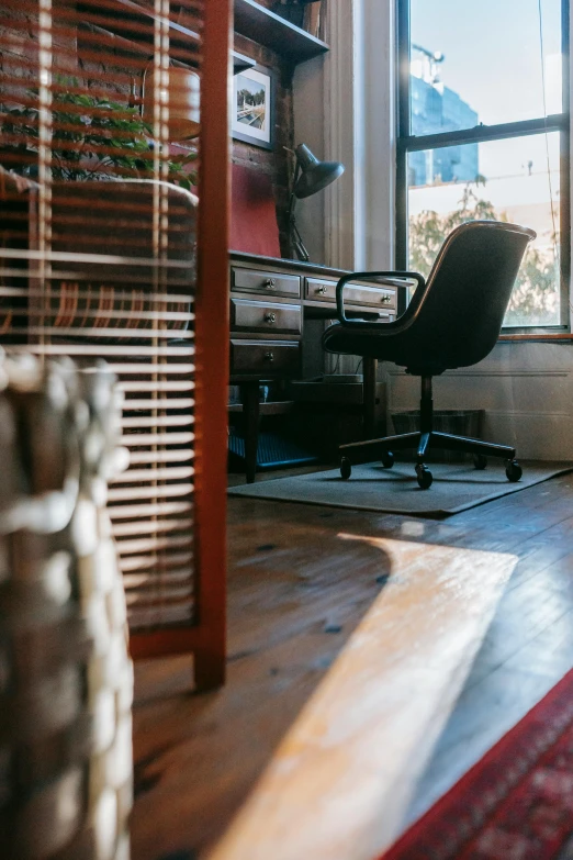 a room with a desk a chair and a window, unsplash, light and space, bay area, sun flare, dwell, warmly lit