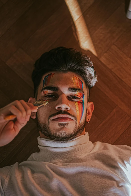 a man that has some paint on his face, an album cover, by Robbie Trevino, trending on pexels, lgbt, diego fernandez, looking down at you, instagram picture