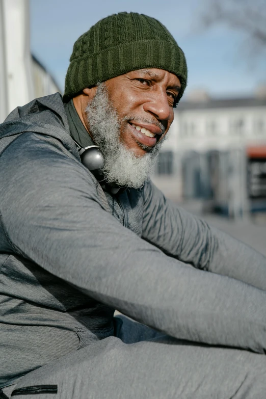 a man with a beard sitting on a bench, wearing fitness gear, african american, old gray hair, portrait featured on unsplash