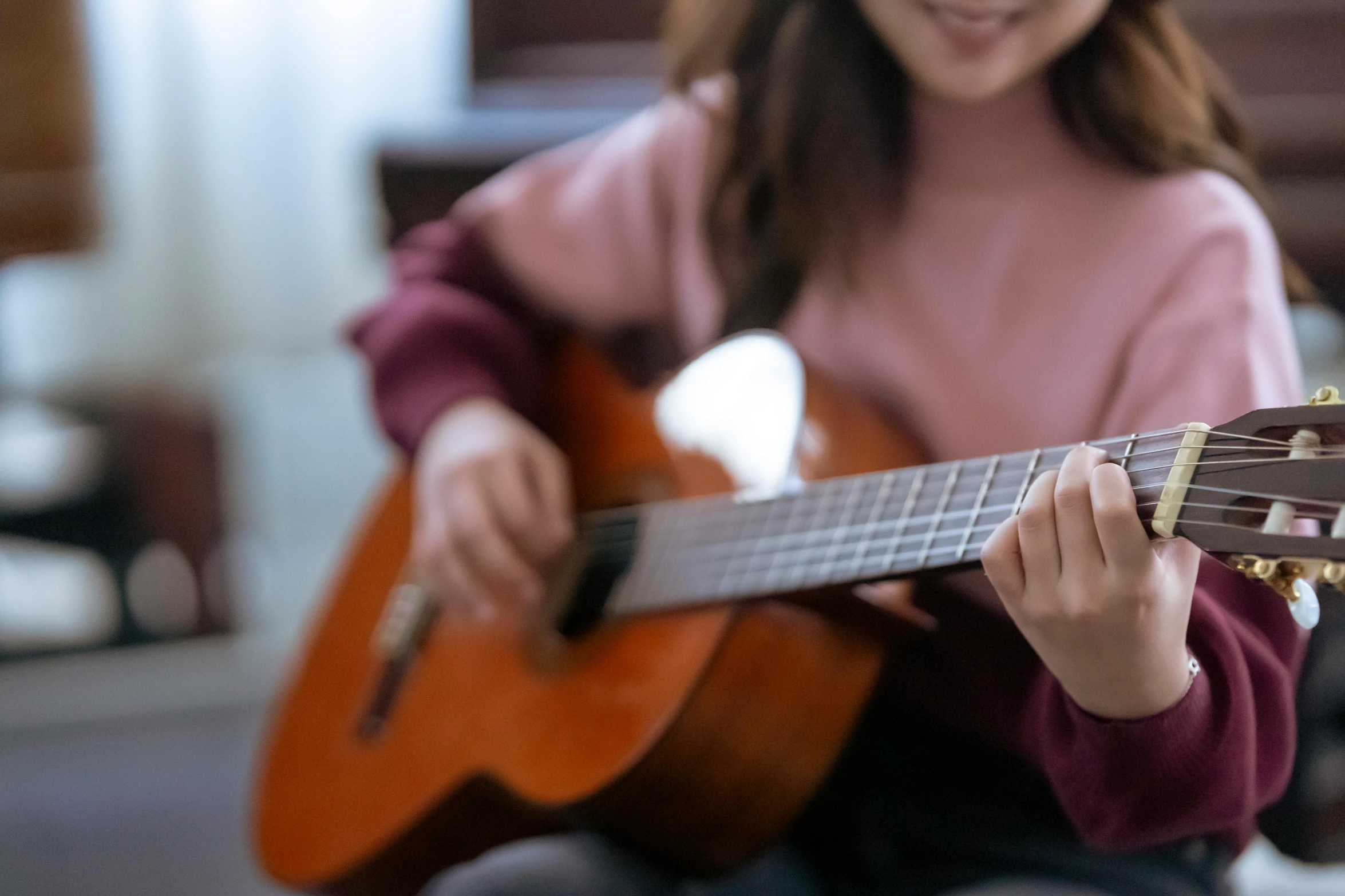 a close up of a person playing a guitar, gemma chen, schools, background image, a young asian woman