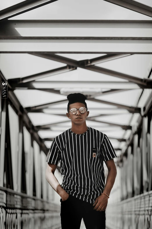 a man standing on a bridge with his hands in his pockets, inspired by Rudy Siswanto, aestheticism, black stripes, trending on r/streetwear, portrait photo, black in