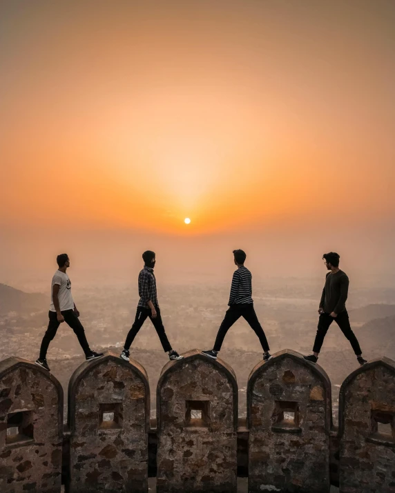 a group of people walking on top of a wall, pexels contest winner, handsome, josh grover, sun rising, studs