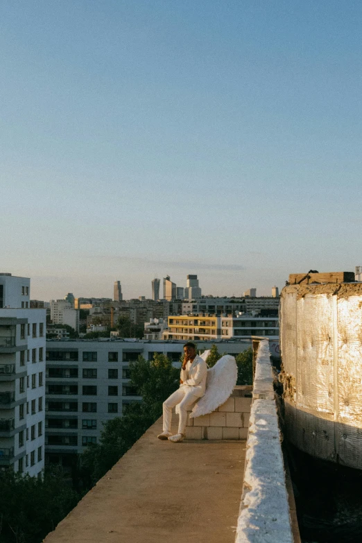 a man standing on top of a roof holding a surfboard, unsplash, brutalism, angel in white linen, neo kyiv, panorama, wedding