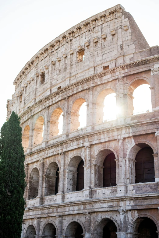 a couple of people that are standing in front of a building, inspired by Romano Vio, pexels contest winner, neoclassicism, sun flare, colosseo, promo image, buildings carved out of stone