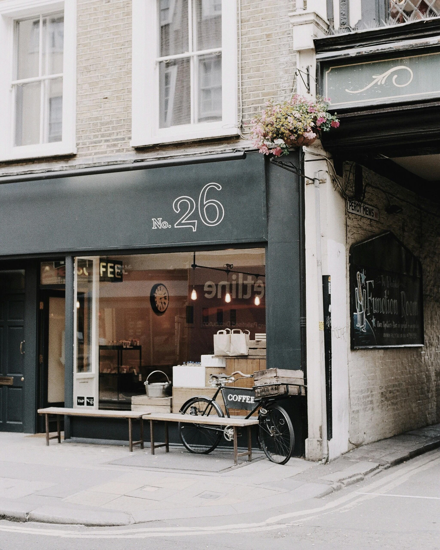 a bicycle parked in front of a coffee shop, trending on unsplash, international typographic style, she is 2 3, london architecture, dwell, 25 years old