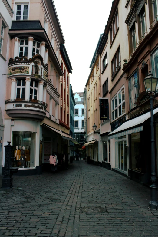 a cobblestone street in a european city, inspired by Georg Friedrich Schmidt, lots of shops, narrow hallway, sleepy, brown