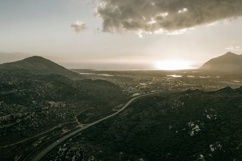 a view from the top of a mountain at sunset, by Daniel Lieske, unsplash contest winner, hurufiyya, the city of santa barbara, road between hills, south african coast, 2 0 0 0's photo