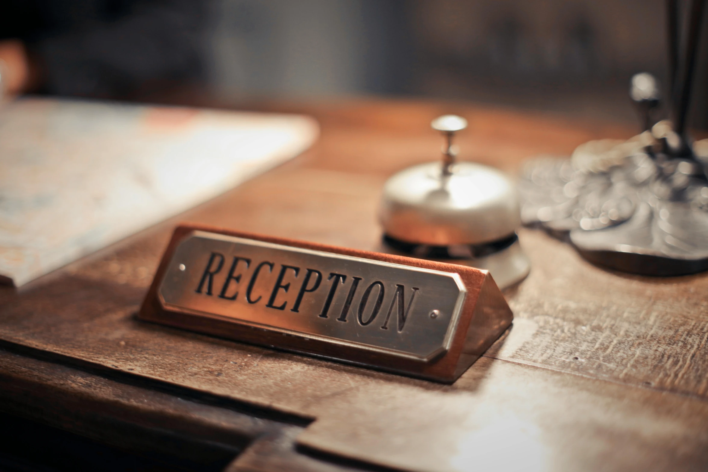 a reception sign sitting on top of a wooden desk, copper, profile image