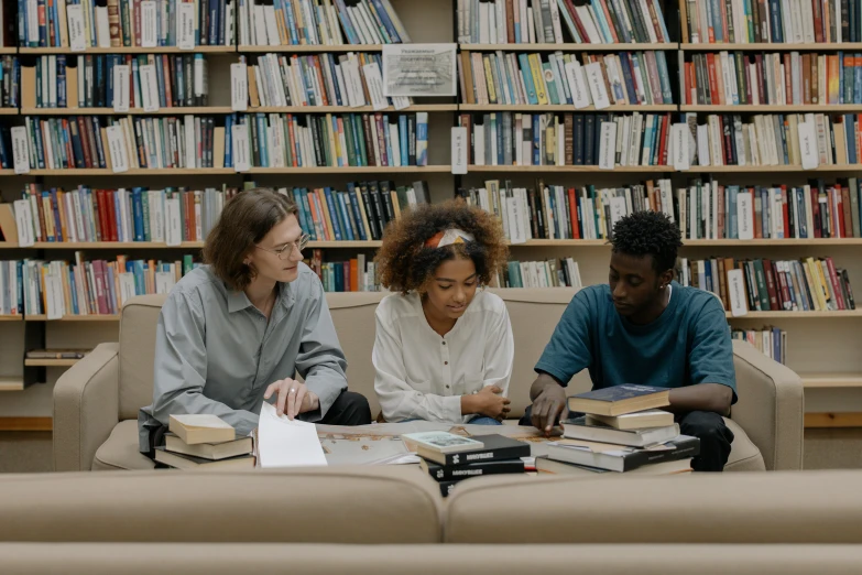 a group of people sitting around a table in a library, pexels contest winner, ashteroth, fan favorite, lgbtq, private school