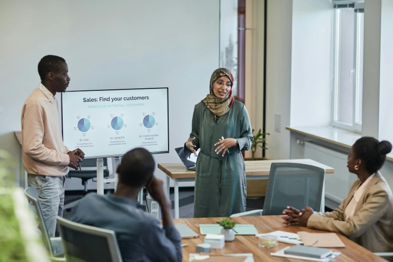 a group of people sitting around a wooden table, pexels contest winner, hurufiyya, giving a speech, working in an office, african ameera al taweel, mit technology review