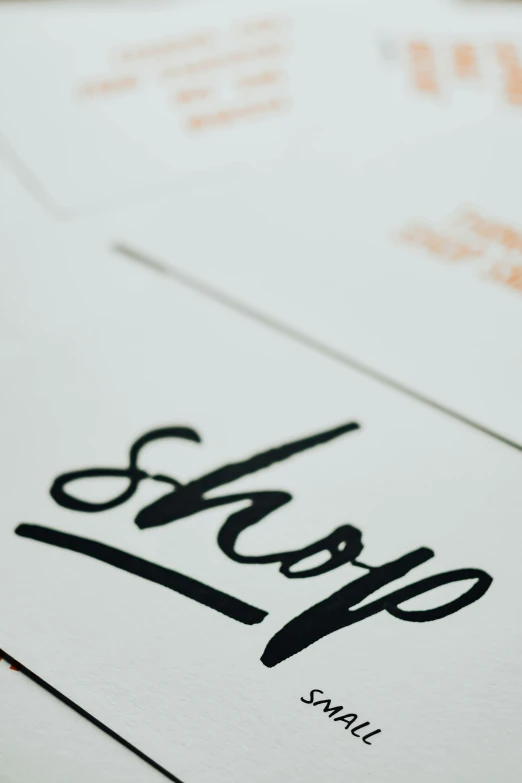 a close up of some type of business cards, a screenprint, by Robbie Trevino, trending on unsplash, drawn on white parchment paper, stop motion, shops, high quality photo