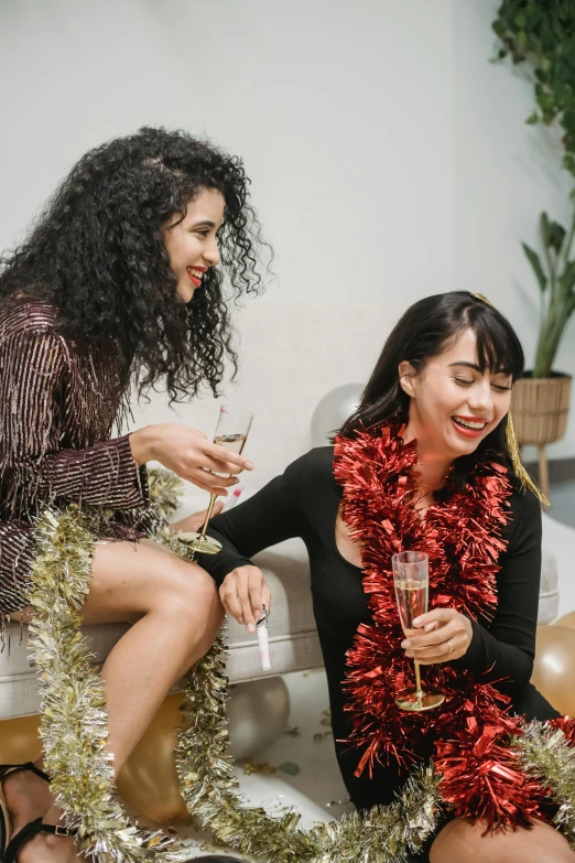 a couple of women sitting on top of a couch, trending on pexels, happening, wearing festive clothing, bubbly, brunette, an asian woman