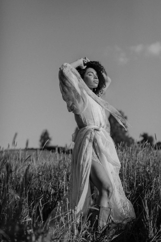 a black and white photo of a woman in a field, pexels contest winner, renaissance, doja cat, in robes, curls and curves, light skin