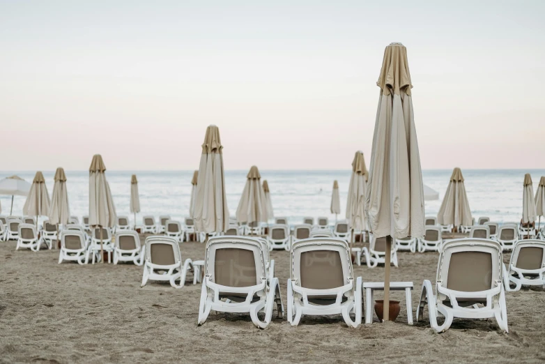 a bunch of chairs and umbrellas on a beach, a portrait, by Carlo Martini, unsplash contest winner, renaissance, white and gold robes, tables and chairs, beige, 15081959 21121991 01012000 4k