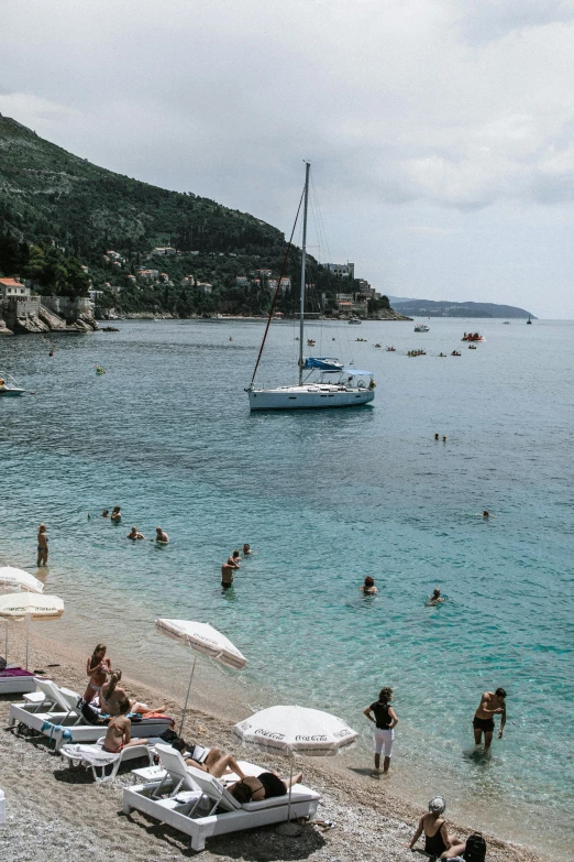 a beach filled with lots of people and umbrellas, relaxing on a yacht at sea, dubrovnik, slide show, square