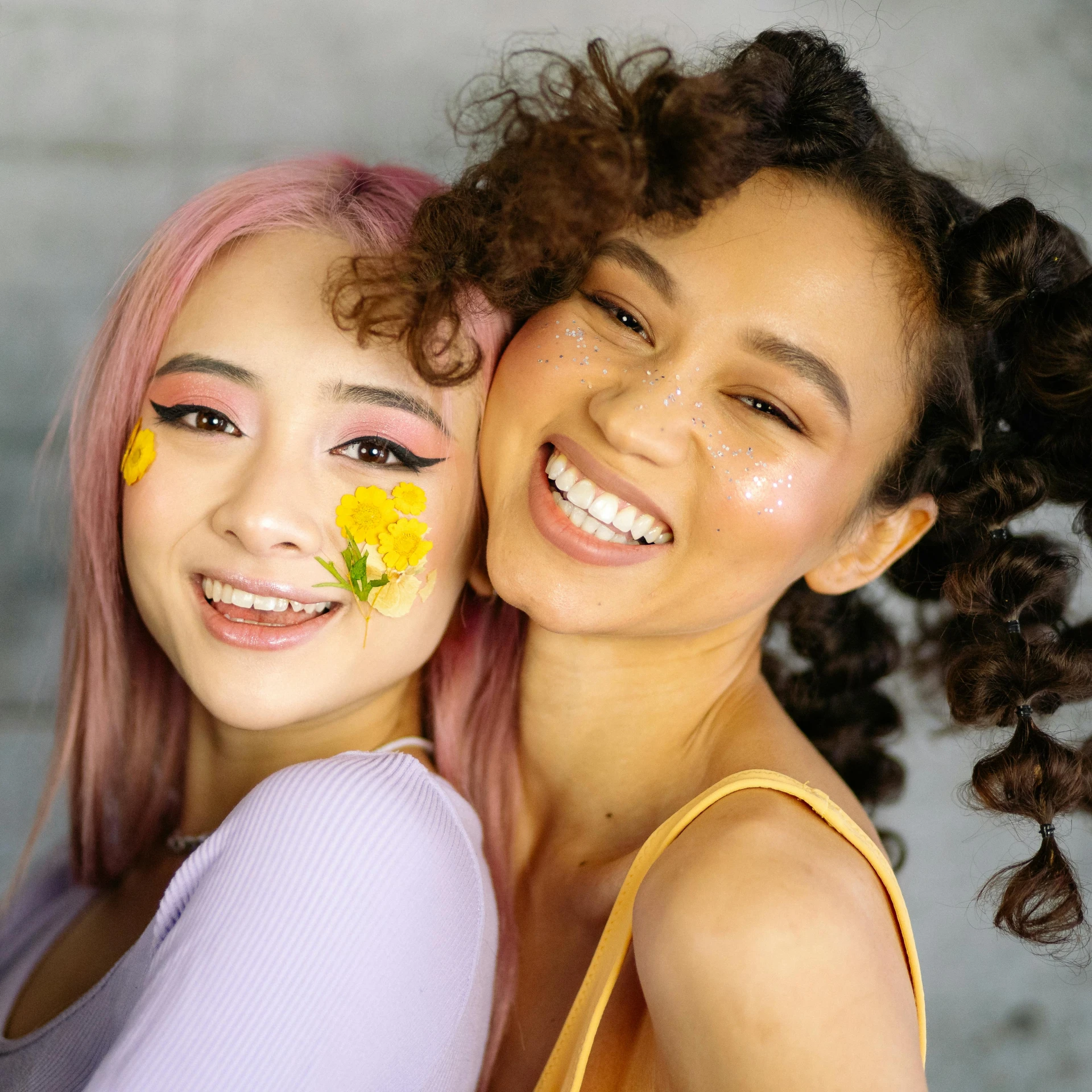 a couple of women standing next to each other, trending on pexels, messy curly pastel hair, zeen chin and terada katsuya, yellow makeup, pokimane