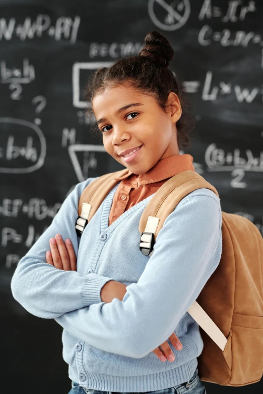 a young girl standing in front of a blackboard, shutterstock contest winner, light-brown skin, math equations in the background, with a backpack, confident stance