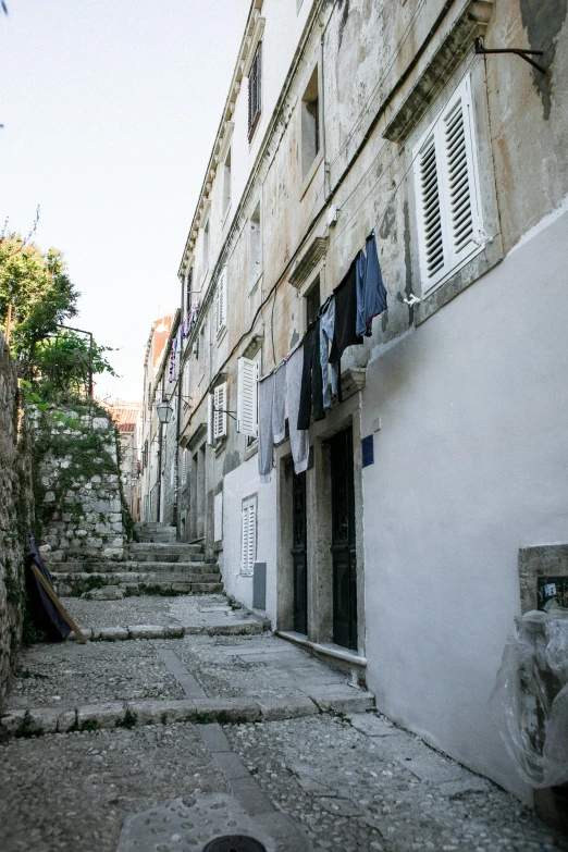 a man riding a skateboard down a cobblestone street, inspired by Ivan Lacković Croata, renaissance, laundry hanging, staggered terraces, croatian coastline, dirty linen robes