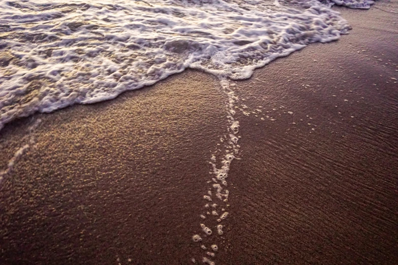 footprints in the sand of a beach at sunset, an album cover, unsplash, land art, very detailed curve, sparkling cove, ignant, streaks