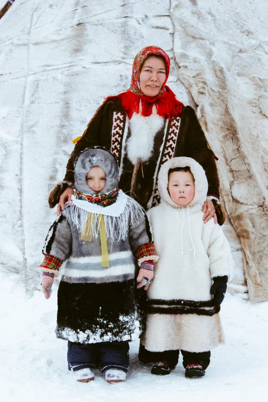 a woman and two children standing in front of a teepee, an album cover, by Jaakko Mattila, pexels contest winner, wearing intricate fur armor, (3 are winter, russian clothes, group photo