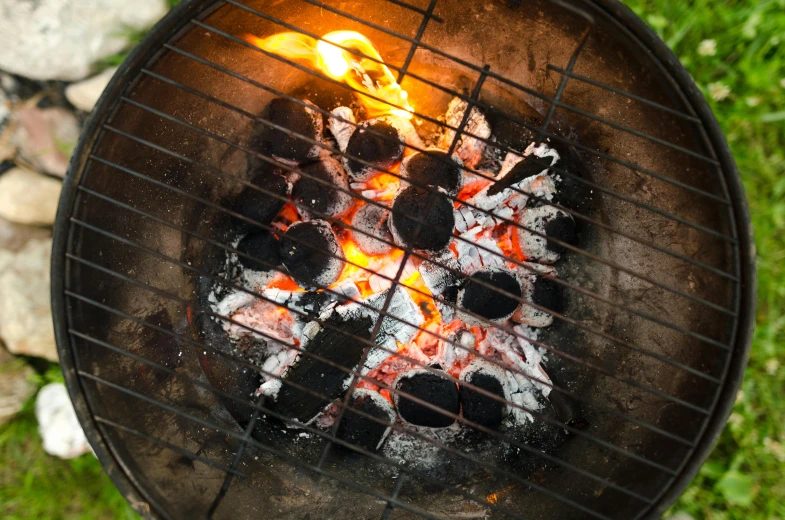 a close up of a grill with a fire in it, an album cover, by Joe Bowler, shutterstock, barbecuing chewing gum, circular, charcoal, recipe