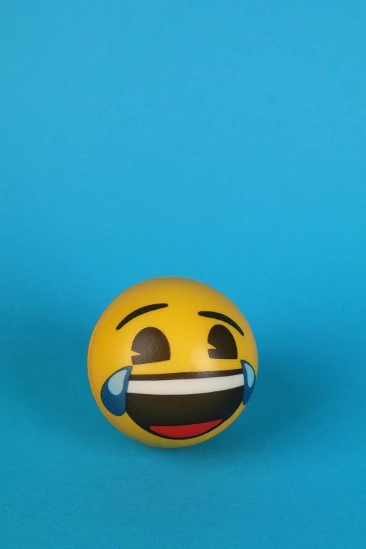 a yellow smiley face ball on a blue background, by Toyen, trending on reddit, happening, screaming and crying, on a gray background, 2019 trending photo, plain background