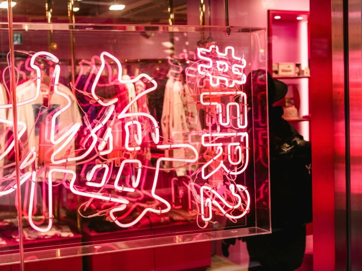 a neon sign in the window of a clothing store, a silk screen, by Julia Pishtar, trending on pexels, graffiti, kenny wong x pop mart, pink and red color scheme, yeezy collection, pink forest