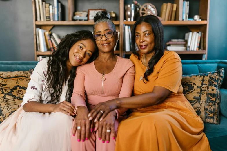 three women sitting on a couch in a living room, a portrait, pexels, african american woman, portrait of family of three, portrait of women embracing, schools