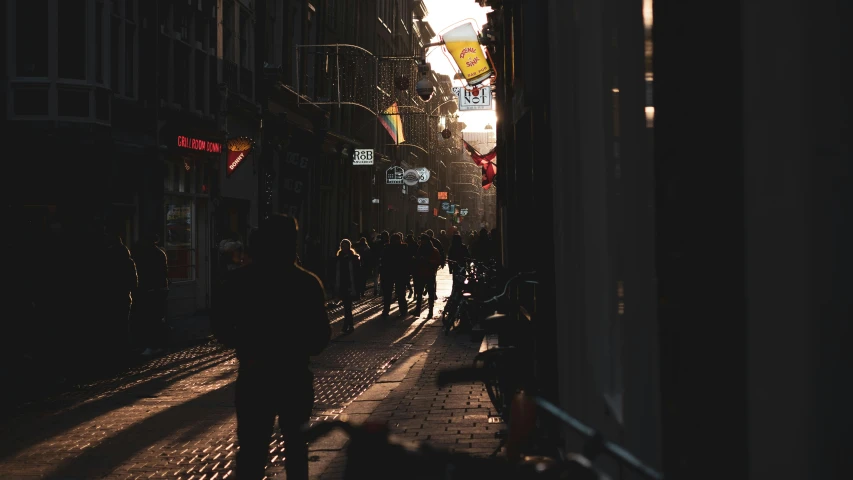 a group of people walking down a street next to tall buildings, by Thomas Wijck, pexels contest winner, happening, warm lighting with cool shadows, storefronts, amsterdam, in an alleyway during the purge