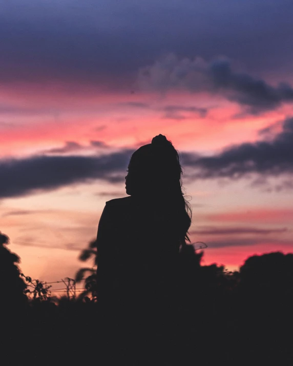 a person standing in front of a sunset, profile image, ☁🌪🌙👩🏾, queer woman, actual photo