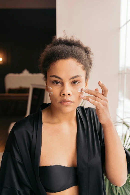 a woman is putting makeup on her face, a portrait, by Cosmo Alexander, trending on pexels, renaissance, mixed race woman, silicone skin, partially cupping her hands, without makeup