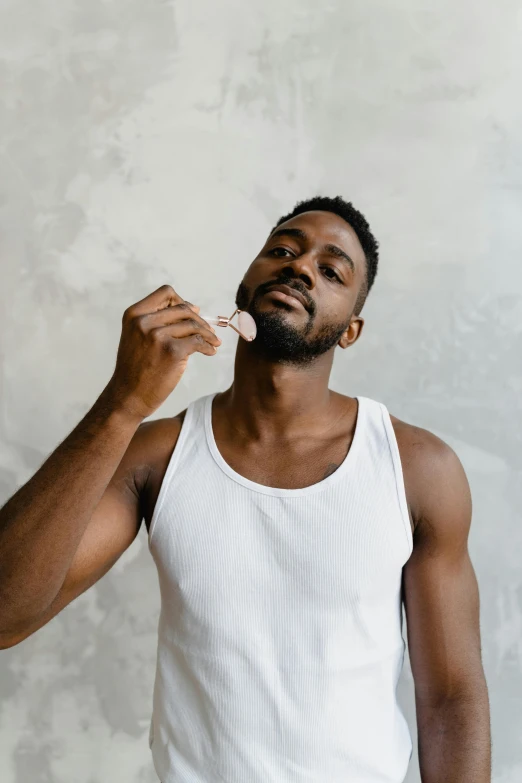 a man brushing his teeth with a toothbrush, by Cosmo Alexander, pexels contest winner, renaissance, wearing a low cut tanktop, man is with black skin, edible crypto, candy treatments