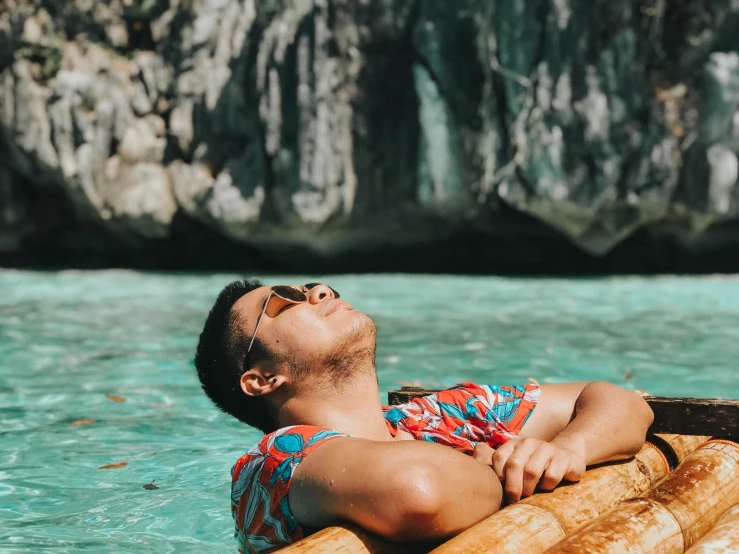 a man laying on a raft in the water, pexels contest winner, tropical background, resting on chest, philippines, profile picture 1024px