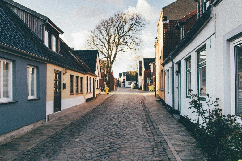 a cobblestone street in a small town, by Jesper Knudsen, pexels contest winner, modernism, background image, in a suburb, hygge, 90's photo