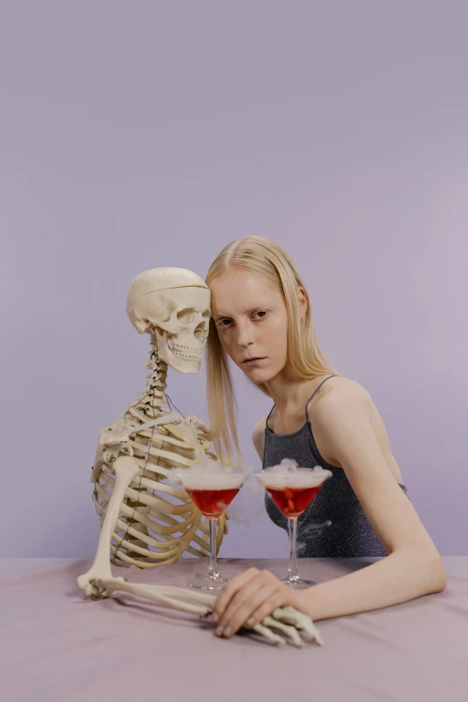 a woman sitting at a table with a skeleton behind her, an album cover, tumblr, extremely pale blond hair, drinking cocktail, neo rauch and nadav kander, which are also skeletal & frail