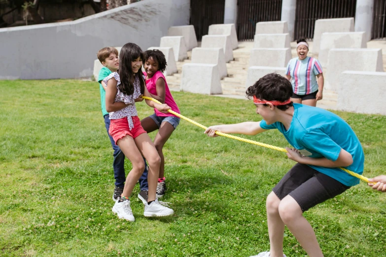 a group of children playing tug rope in a park, pexels contest winner, american barbizon school, 80s outdoor retro arcade, finn wolfhard, on set, thumbnail