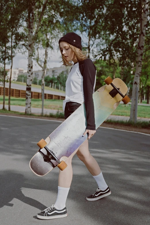 a woman walking down a street holding a skateboard, a colorized photo, by Julia Pishtar, unsplash, iridescent visor, skate park, alexey egorov, on a gray background