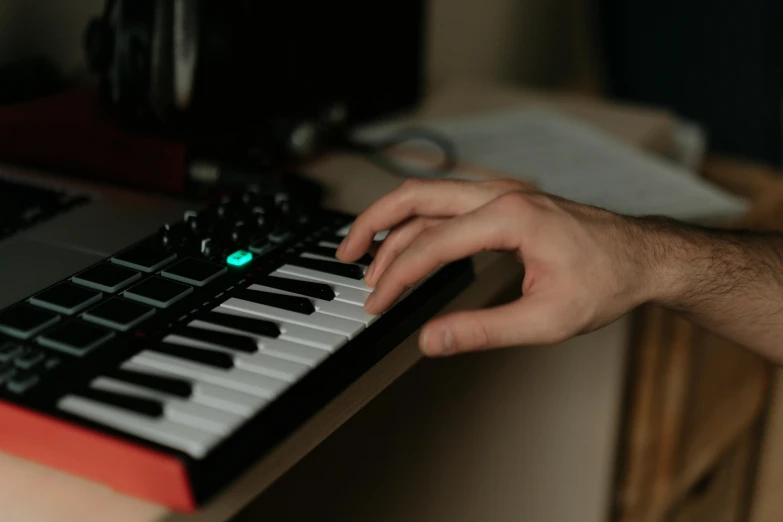 a close up of a person's hand on a keyboard, an album cover, inspired by Elsa Bleda, trending on pexels, synthetism, holding controller, in his basement studio, portrait shot 8 k, portrait of small